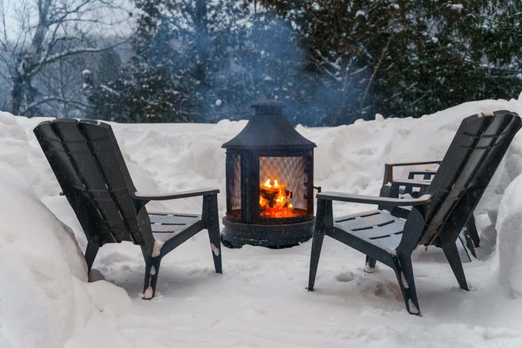 Feu extérieur devant un chalet enneigé des Chalets dans le Nord
